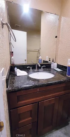a bathroom with a granite countertop sink and a mirror