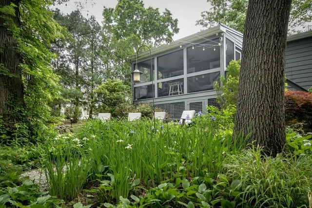 a view of a brick house with a yard and large trees