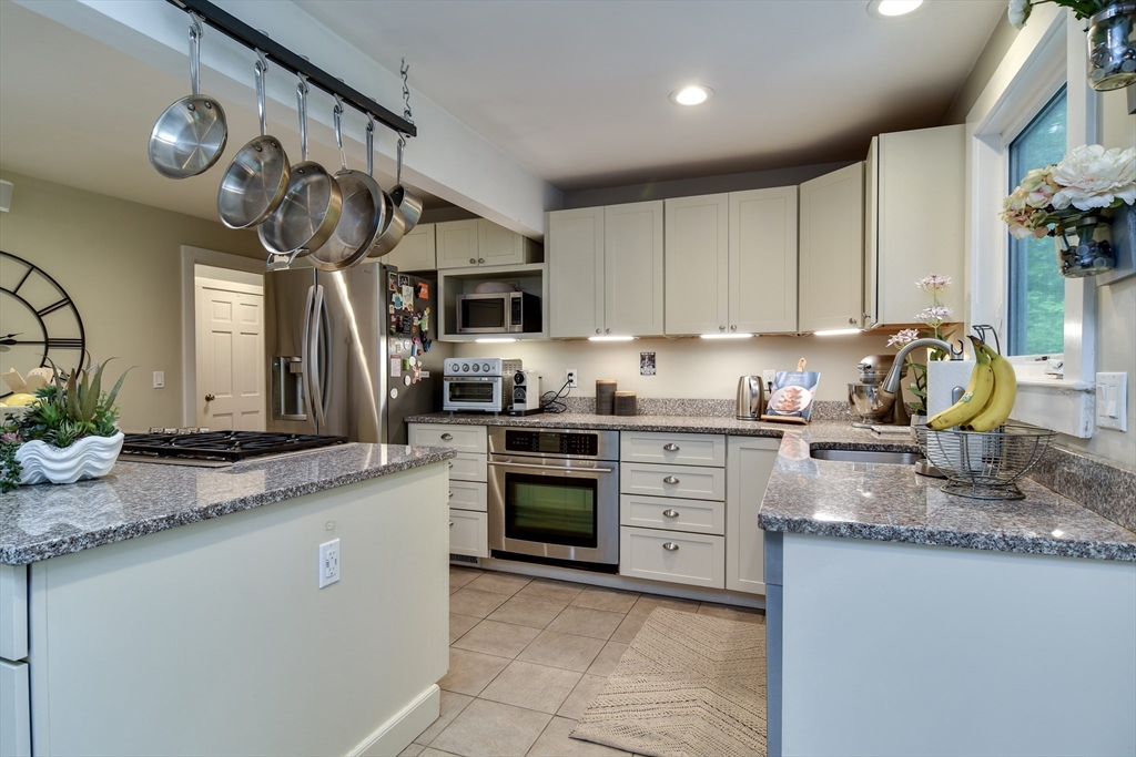 76 Pleasant Street South Natick, MA 01760 - Photo 8 of 36 a kitchen with kitchen island granite countertop a sink a counter space appliances and cabinets