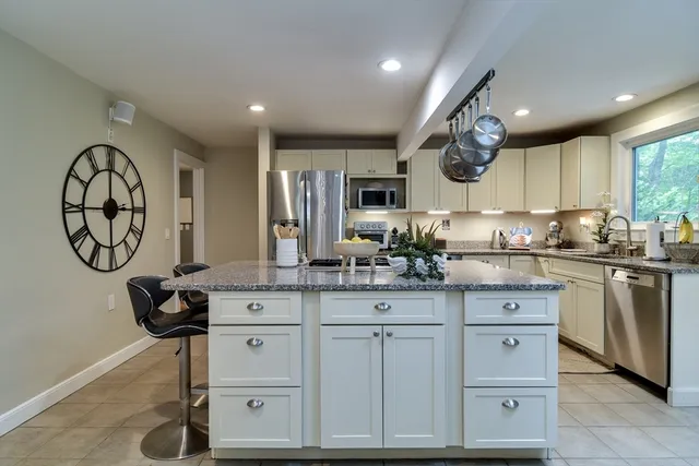 a kitchen with white cabinets and chandelier