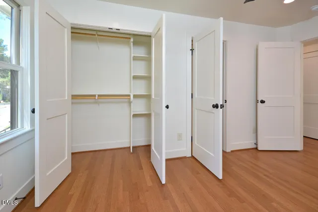 a view of empty room with wooden floor