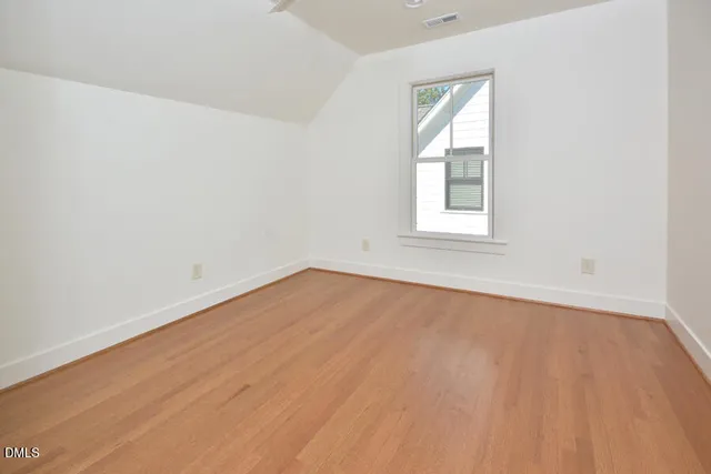 a kitchen with white cabinets and a wooden floor