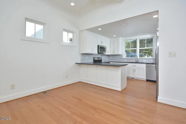 a kitchen with granite countertop a stove a sink and a microwave