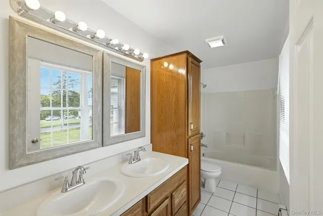 a bathroom with a double vanity sink mirror and shower