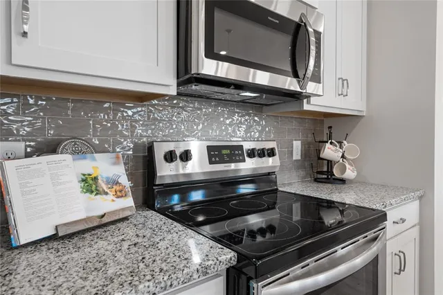 a kitchen with stainless steel appliances granite countertop a stove a microwave and sink