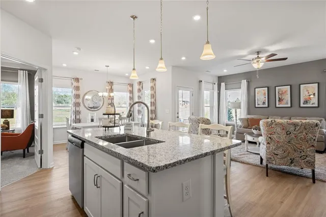 a kitchen with granite countertop a sink a counter top space and living room view