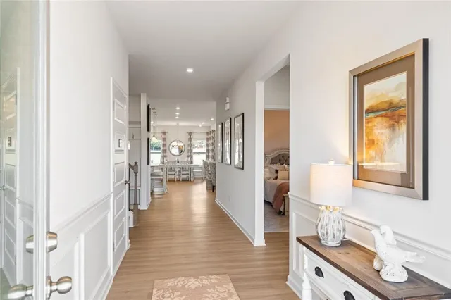 a view of a hallway with wooden floor and a bathroom
