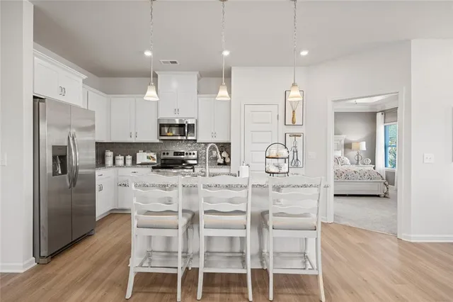 a kitchen with stainless steel appliances kitchen island granite countertop a refrigerator and a stove top oven