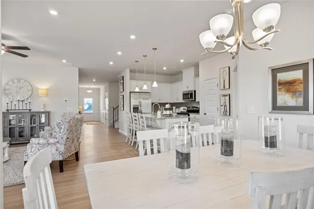 a kitchen with stainless steel appliances kitchen island granite countertop a table and chairs in it