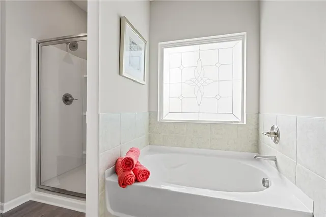 a white bath tub and shower sitting next to a window