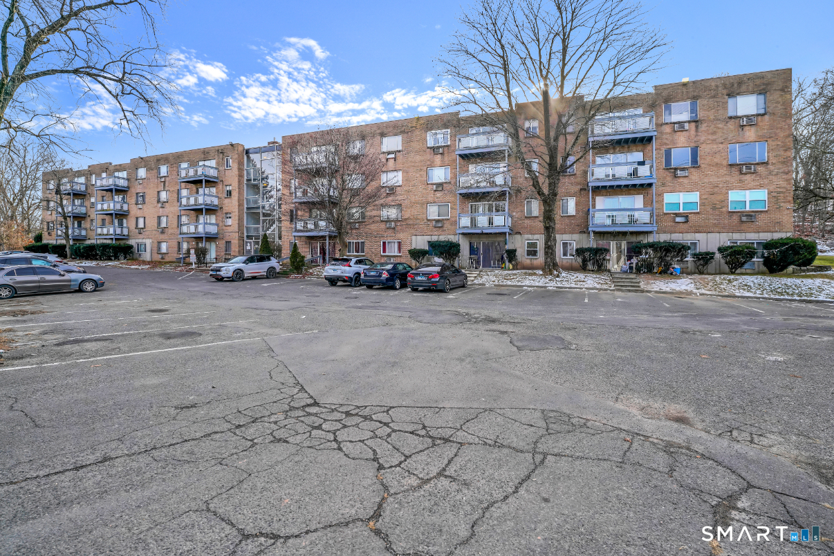 279 Oakville Avenue, Unit B12 Waterbury, CT 06708 - Photo 2 of 8 a view of a building with large trees