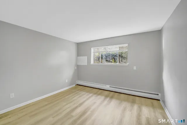 a view of a room with wooden floor and window