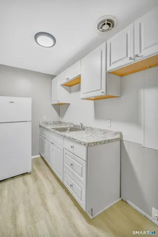 a kitchen with granite countertop cabinets stainless steel appliances and a sink