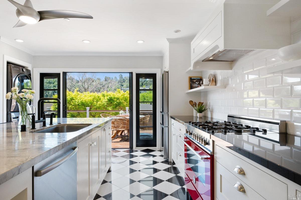 a kitchen with stainless steel appliances granite countertop a sink a stove and a wooden cabinets