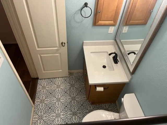 a bathroom with a toilet a sink and a mirror