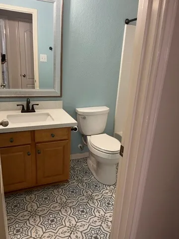 a bathroom with a toilet sink and mirror