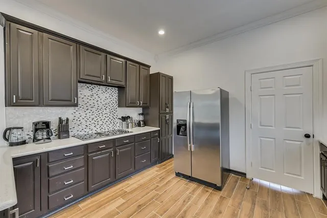 a kitchen with stainless steel appliances granite countertop a refrigerator and a stove top oven