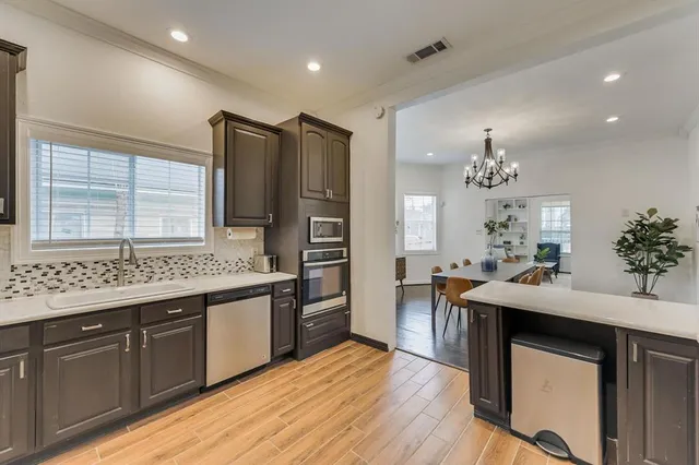 a kitchen with stainless steel appliances kitchen island granite countertop a sink stove and refrigerator