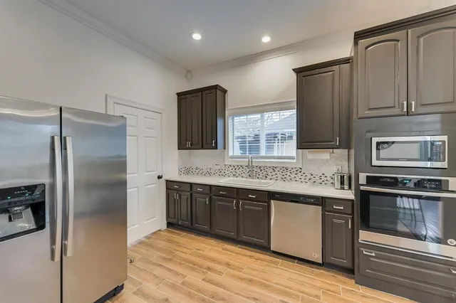 a kitchen with stainless steel appliances granite countertop a refrigerator and a stove top oven