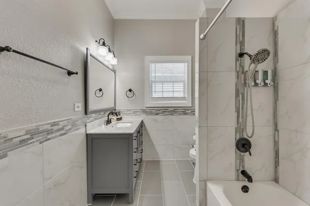 a bathroom with a sink and mirror with bathtub
