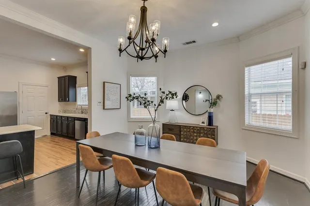 a view of a dining room with furniture a chandelier and wooden floor