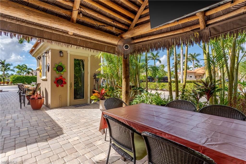 13446 Ladyfish Lane Naples, FL 34114 - Photo 13 of 44 a view of a patio with table and chairs potted plants with floor to ceiling window and potted plants