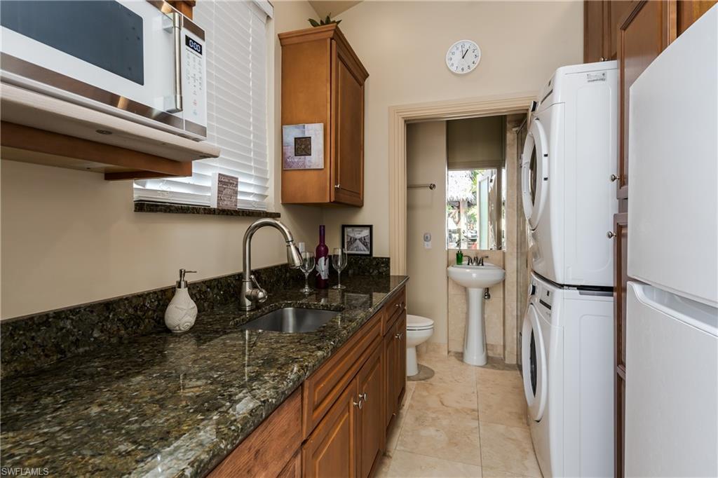 13446 Ladyfish Lane Naples, FL 34114 - Photo 23 of 44 a kitchen with a refrigerator and a sink
