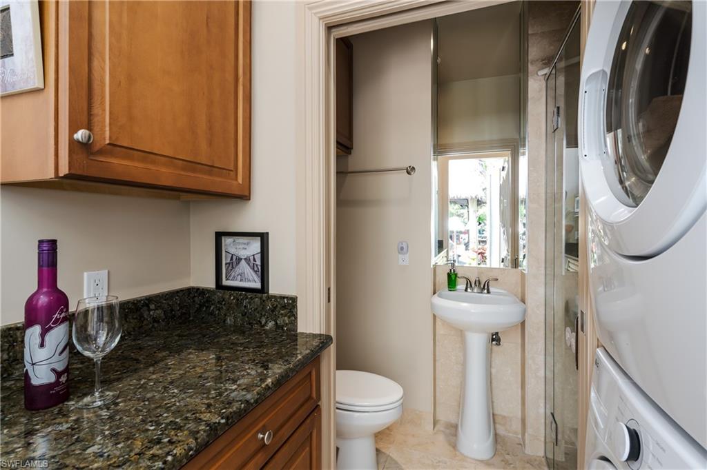 13446 Ladyfish Lane Naples, FL 34114 - Photo 24 of 44 a bathroom with a granite countertop toilet and a sink