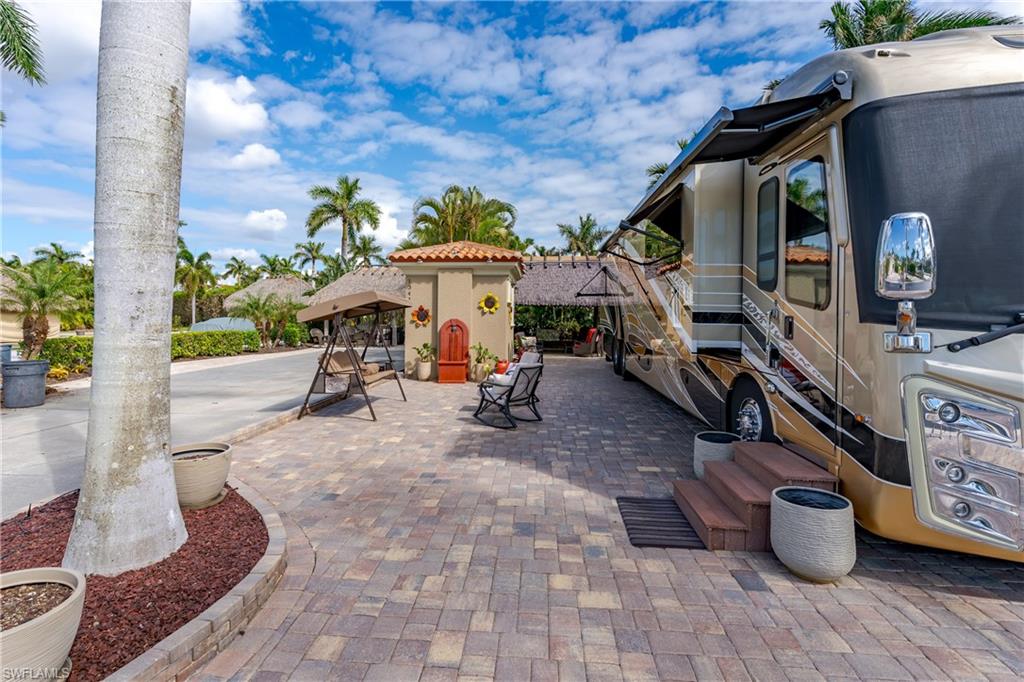 13446 Ladyfish Lane Naples, FL 34114 - Photo 35 of 44 a view of a patio with table and chairs potted plants