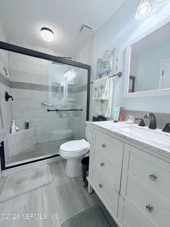 a bathroom with a sink a toilet and shower