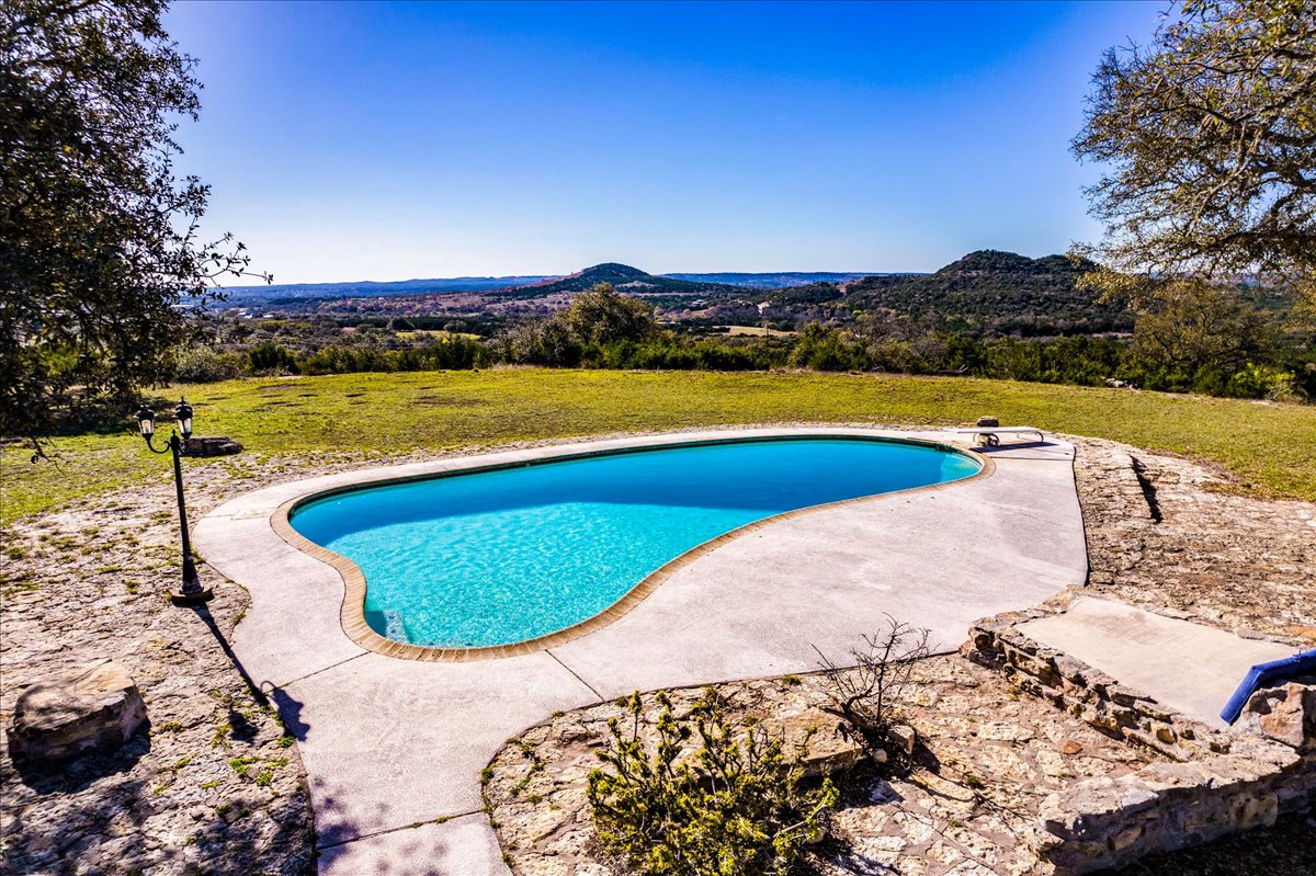 9763 Ranch Road 1623 Blanco, TX 78606 - Photo 1 of 40 Swimming pool featuring a diving board, a patio area, and a lawn