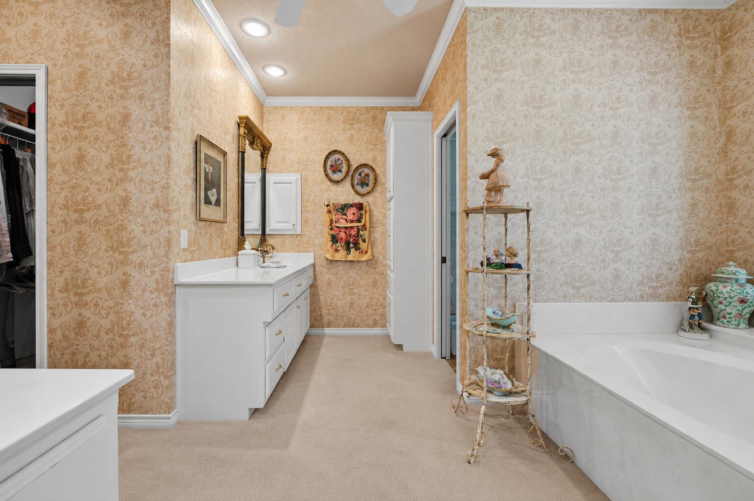 7402 95th Street Lubbock, TX 79424 - Photo 22 of 43 a bathroom with a double vanity sink a mirror and a bathtub
