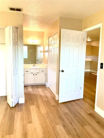a large white kitchen with white cabinets and wooden floor