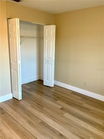 an empty room with wooden floor and entrance
