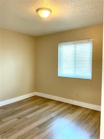 a view of a room with wooden floor and a window