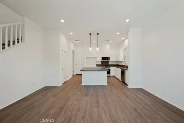 a large kitchen with stainless steel appliances kitchen island a large counter top and a stove top oven