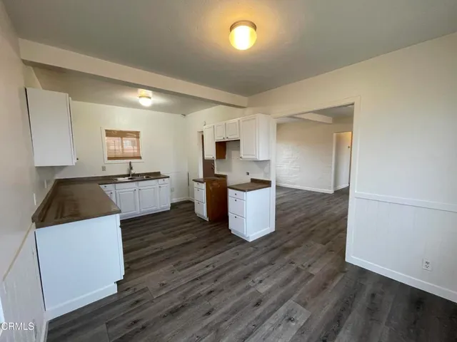 a kitchen with granite countertop white cabinets and sink