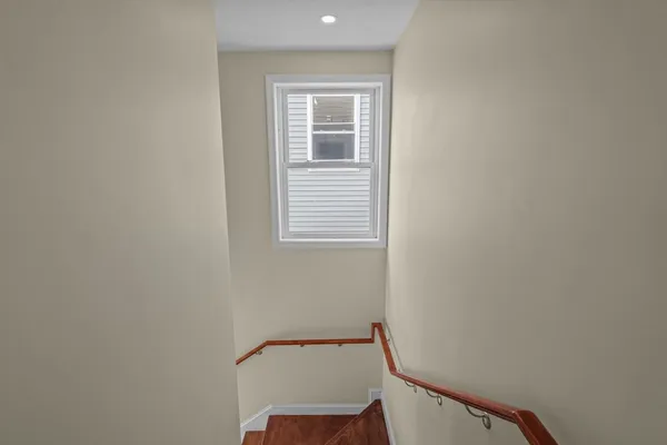 a view of a hallway with a chair and a window