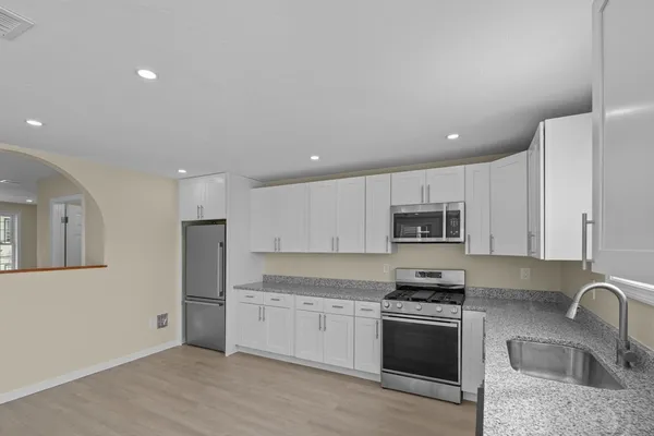 a kitchen with stainless steel appliances granite countertop a refrigerator sink and stove