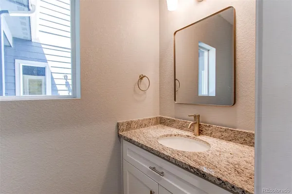 a bathroom with a granite countertop sink and a mirror