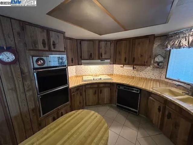 a kitchen with granite countertop a refrigerator and a sink