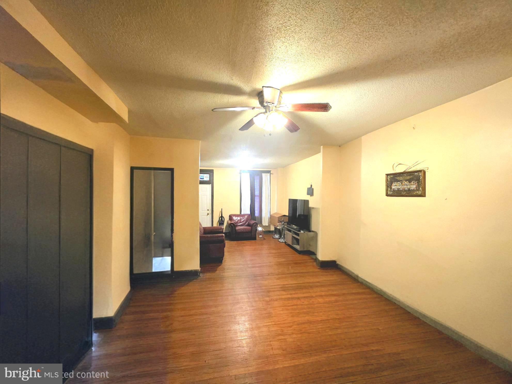 2730 East Chase Street Baltimore, MD 21213 - Photo 3 of 17 a view of a livingroom with furniture a ceiling fan and wooden floor