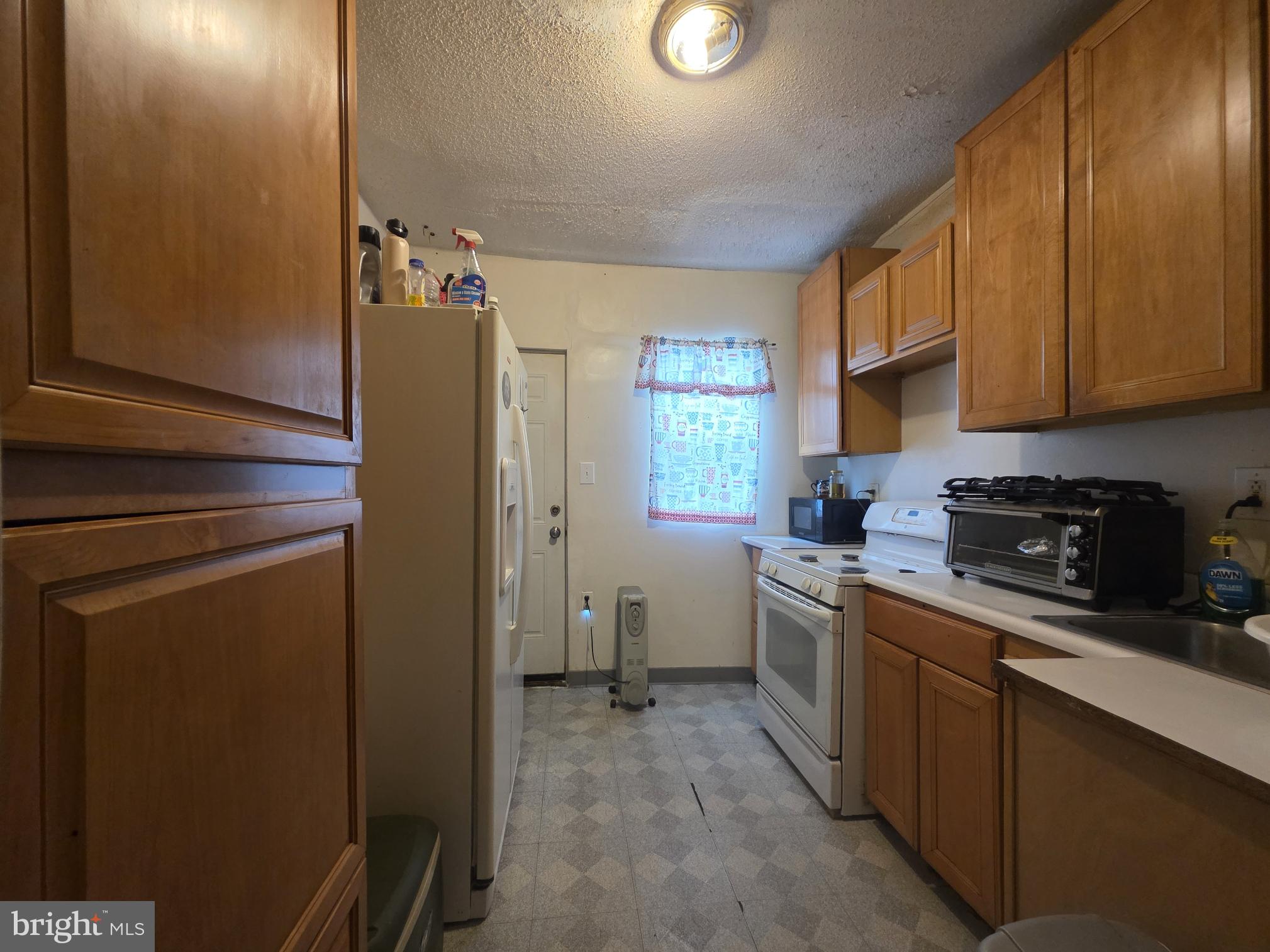 2730 East Chase Street Baltimore, MD 21213 - Photo 4 of 17 a kitchen with stainless steel appliances granite countertop a refrigerator and a stove top oven