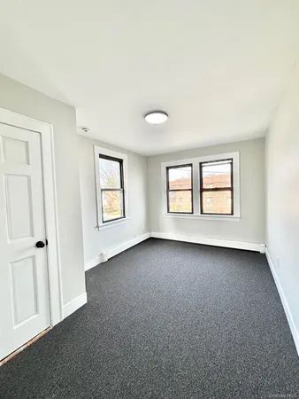 an empty room with windows and closet area