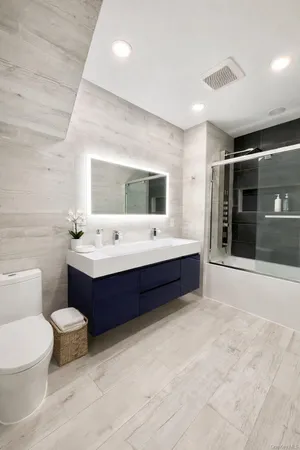 a spacious bathroom with a toilet a sink and mirror