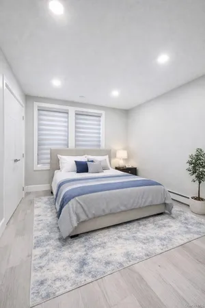a bedroom with a large bed and a potted plant