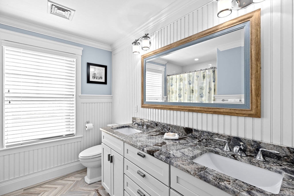 170 Otis Street Hingham, MA 02043 - Photo 28 of 42 a bathroom with a granite countertop sink toilet a mirror and a window