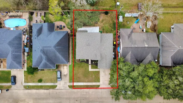 an aerial view of residential houses with outdoor space and parking