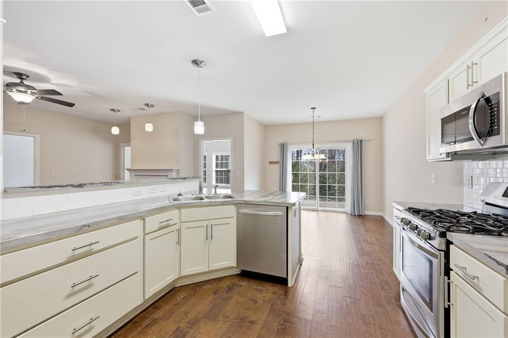 166 Senior Circle Northeast Gainesville, GA 30501 - Photo 14 of 32 a large white kitchen with stainless steel appliances granite countertop a stove and a wooden floors