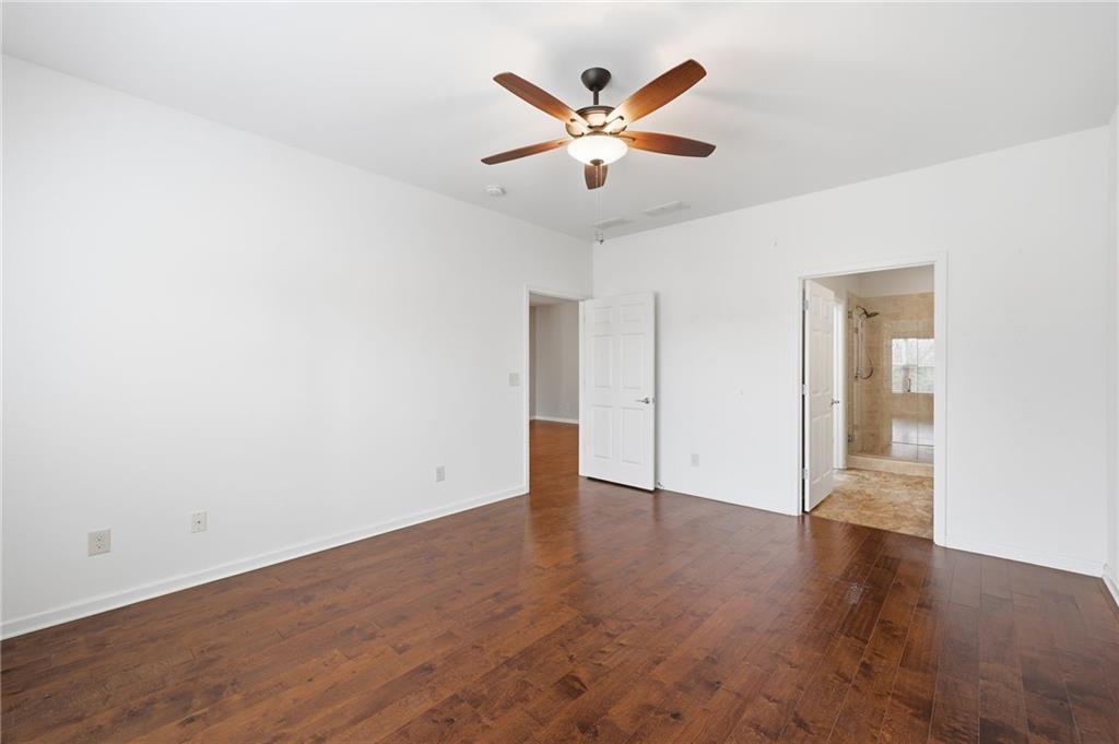 166 Senior Circle Northeast Gainesville, GA 30501 - Photo 19 of 32 an empty room with wooden floor and ceiling fan
